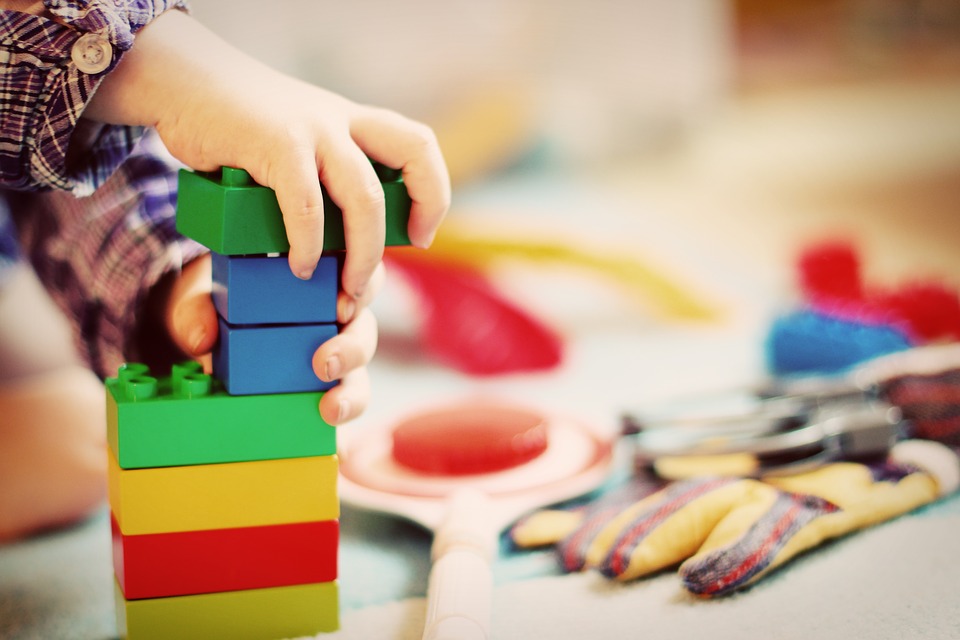 Enfant qui fait une tour avec des morceaux de lego